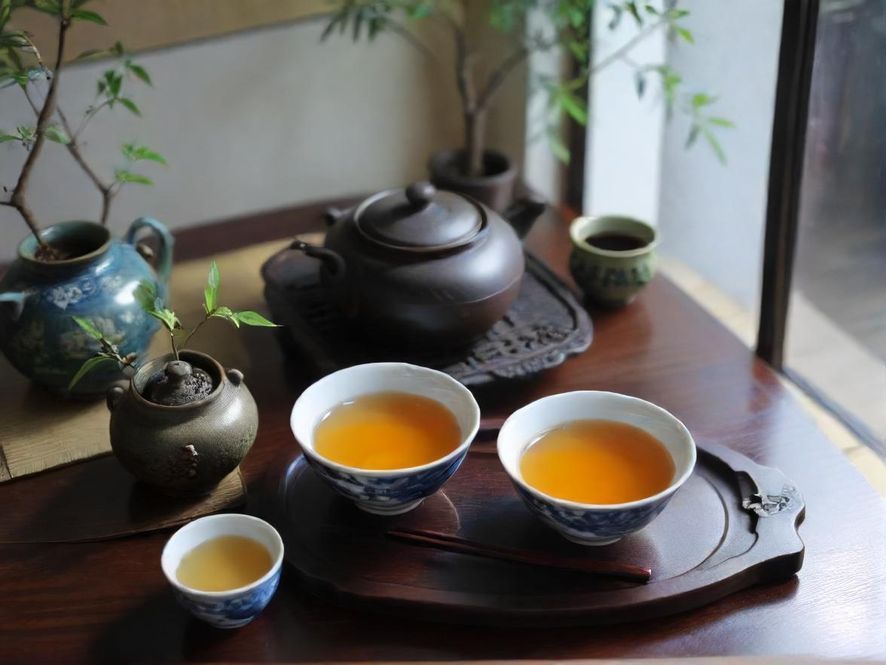 一位气质优雅的茶艺师在温馨茶室中专注泡茶的侧面特写,光线柔和,营造出宁静唯美的意境。